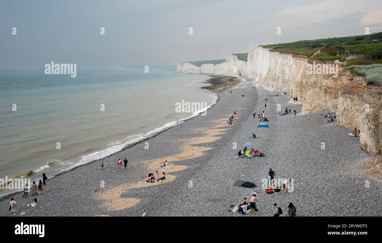 Les gens se détendent dans la plage de galets. Birling Gap, sept sœurs falaises blanches, Angleterre Banque D'Images