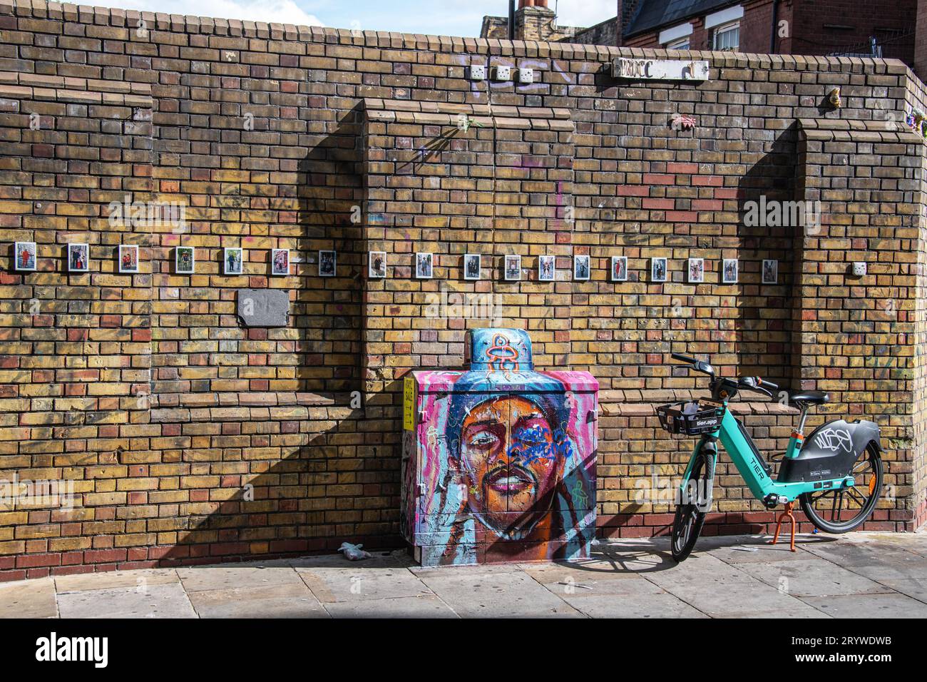 Un vélo de location de niveau contre un mur et Street art à Brick Lane, Londres, E1. Banque D'Images