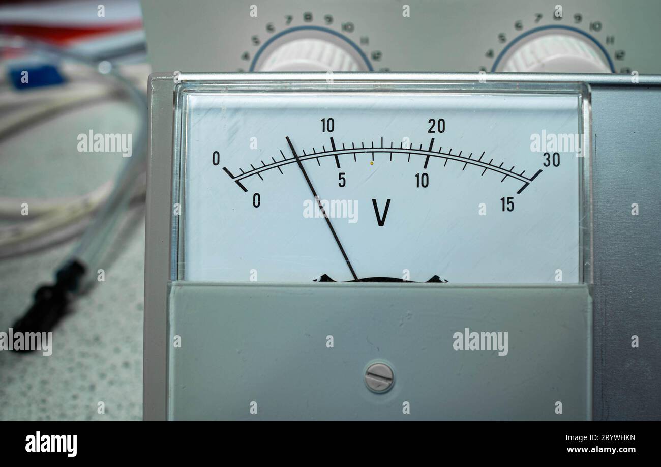 Vue détaillée du panneau d'affichage d'un voltmètre analogique pour une utilisation en sciences ou en classe d'éducation. Banque D'Images
