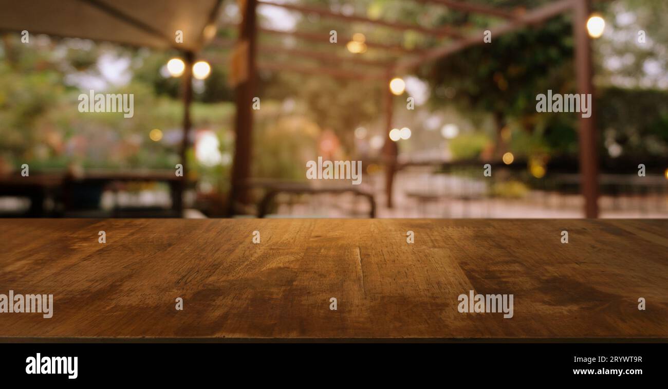 Image de la table en bois devant le fond flou abstrait des lumières de jardin extérieures. peut être utilisé pour l'affichage ou le montage de votre Banque D'Images