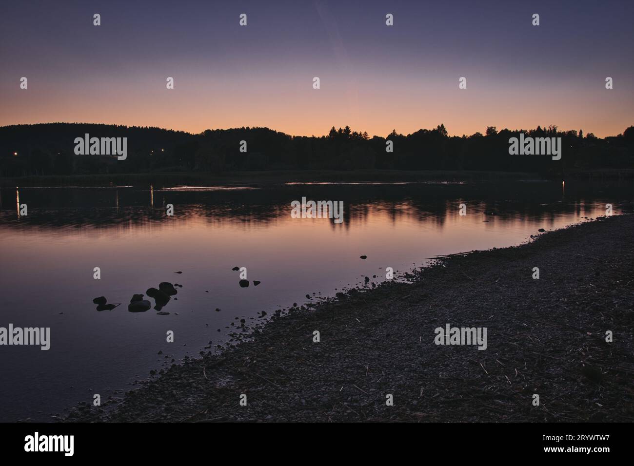 Lac avec le reflet des montagnes et des lumières sur la surface de l'eau à Gmund am Tegernsee, Allemagne Banque D'Images