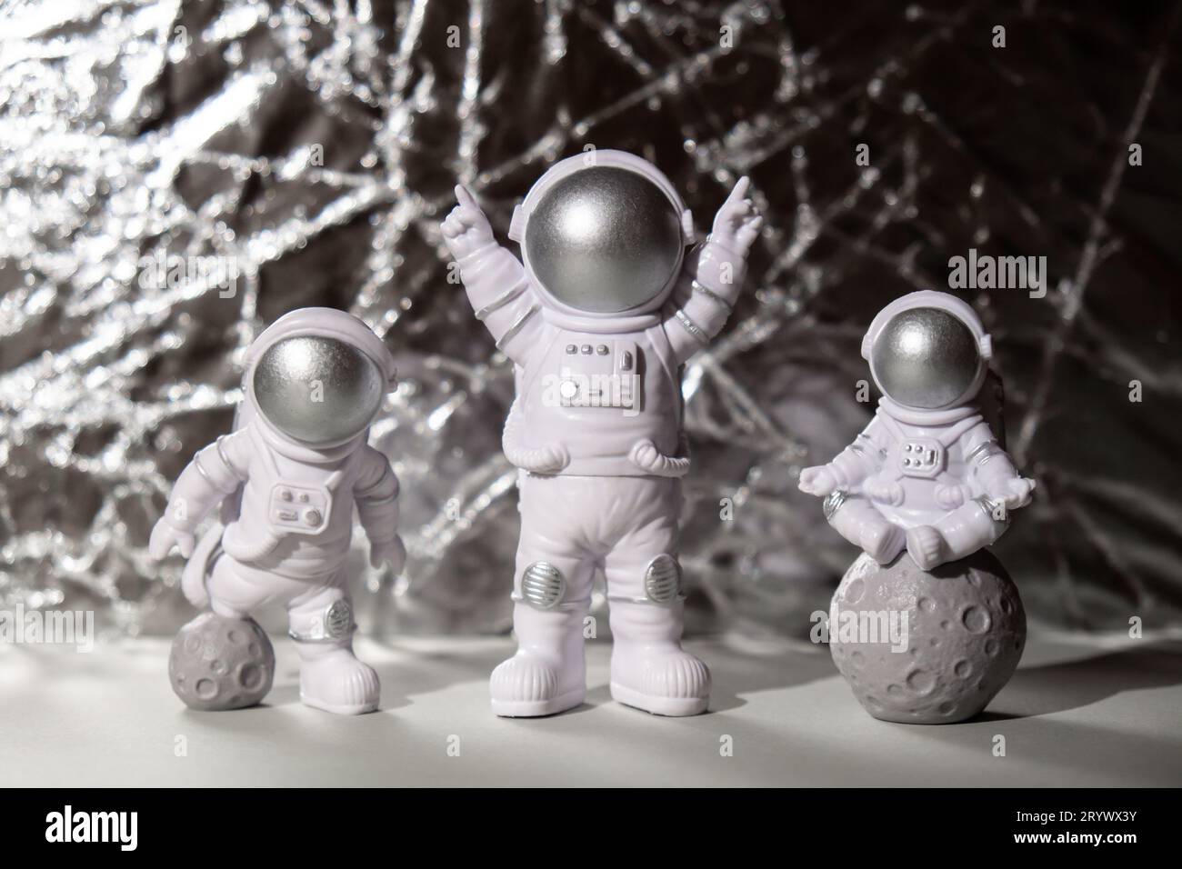 Trois jouets en plastique figure astronaute sur fond argenté Copy space. Concept de voyage hors de la terre, commercial d'homme spatial privé Banque D'Images