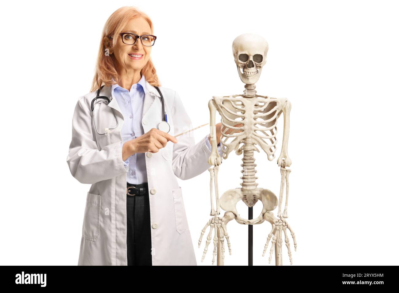 Femme médecin souriant et posant à côté d'un squelette humain isolé sur fond blanc Banque D'Images