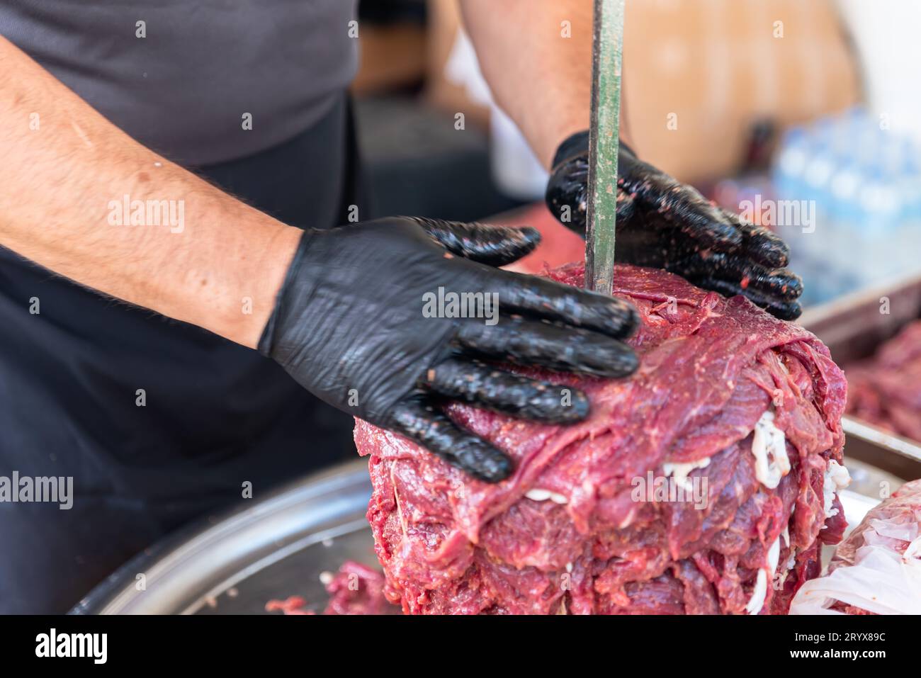 Le maître prépare du kebab turc à cuire à partir de viande rouge, de viande de doner kebab non cuite, de gyros grecs à la broche dans un restaurant . Photo de haute qualité Banque D'Images