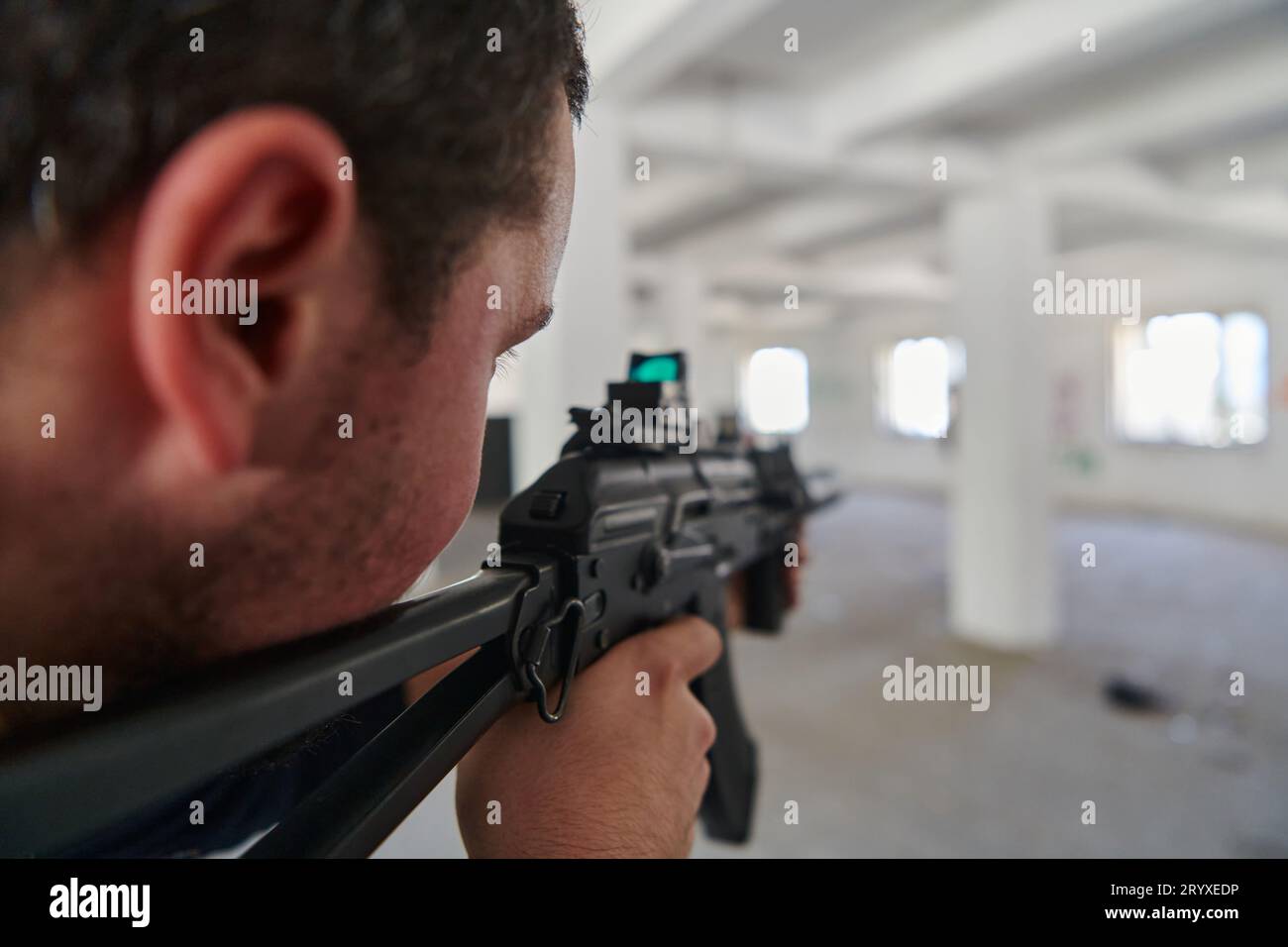 Dans un bâtiment abandonné, un terroriste vise avec un fusil un adversaire militaire, engagé dans une bataille féroce pour le territoire Banque D'Images