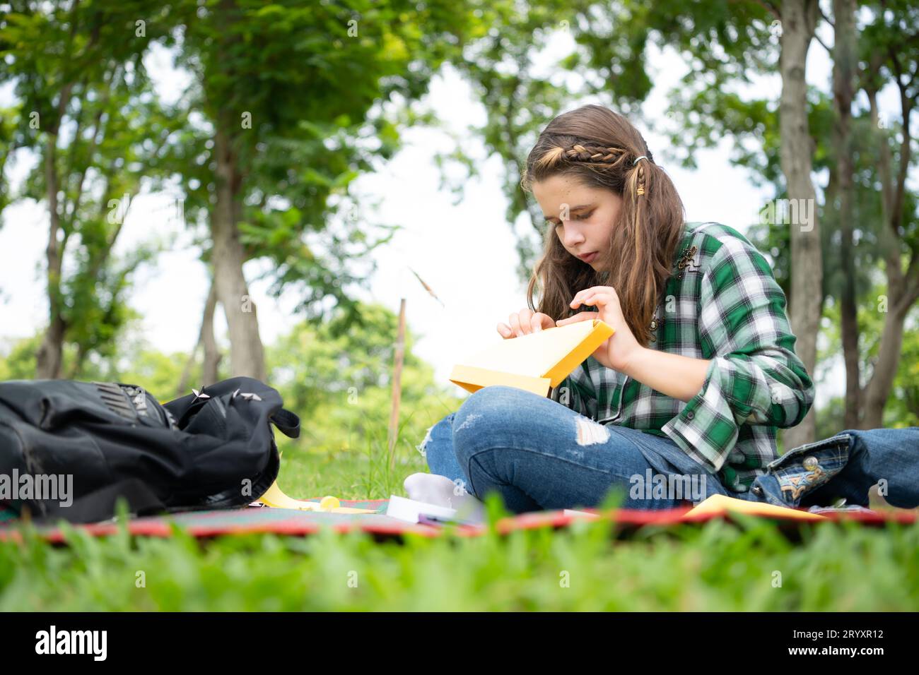 Petite fille en vacances dans le parc avec l'artisanat de faire un bec d'oiseau avec du papier peut utiliser vos doigts pour bouger votre bouche. Banque D'Images