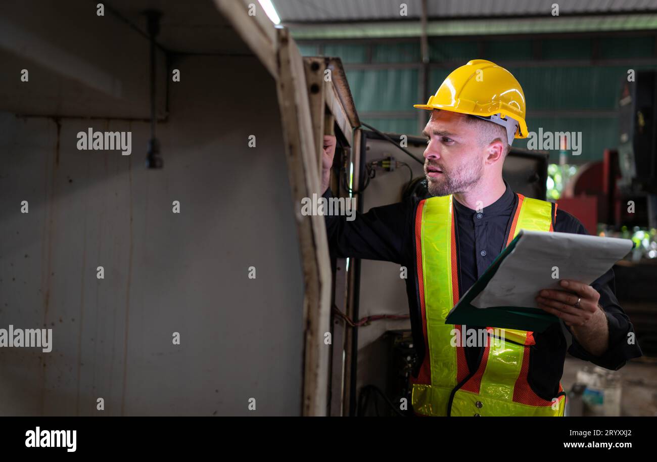 L'ingénieur inspecte le système électrique et répare le système mécanique dans l'armoire de commande de la machine. pour le m Banque D'Images