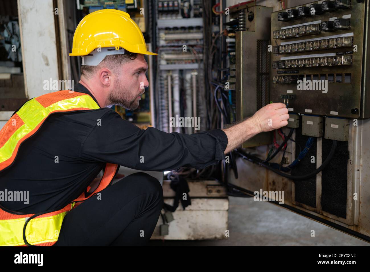 L'ingénieur inspecte le système électrique et répare le système mécanique dans l'armoire de commande de la machine. pour le m Banque D'Images