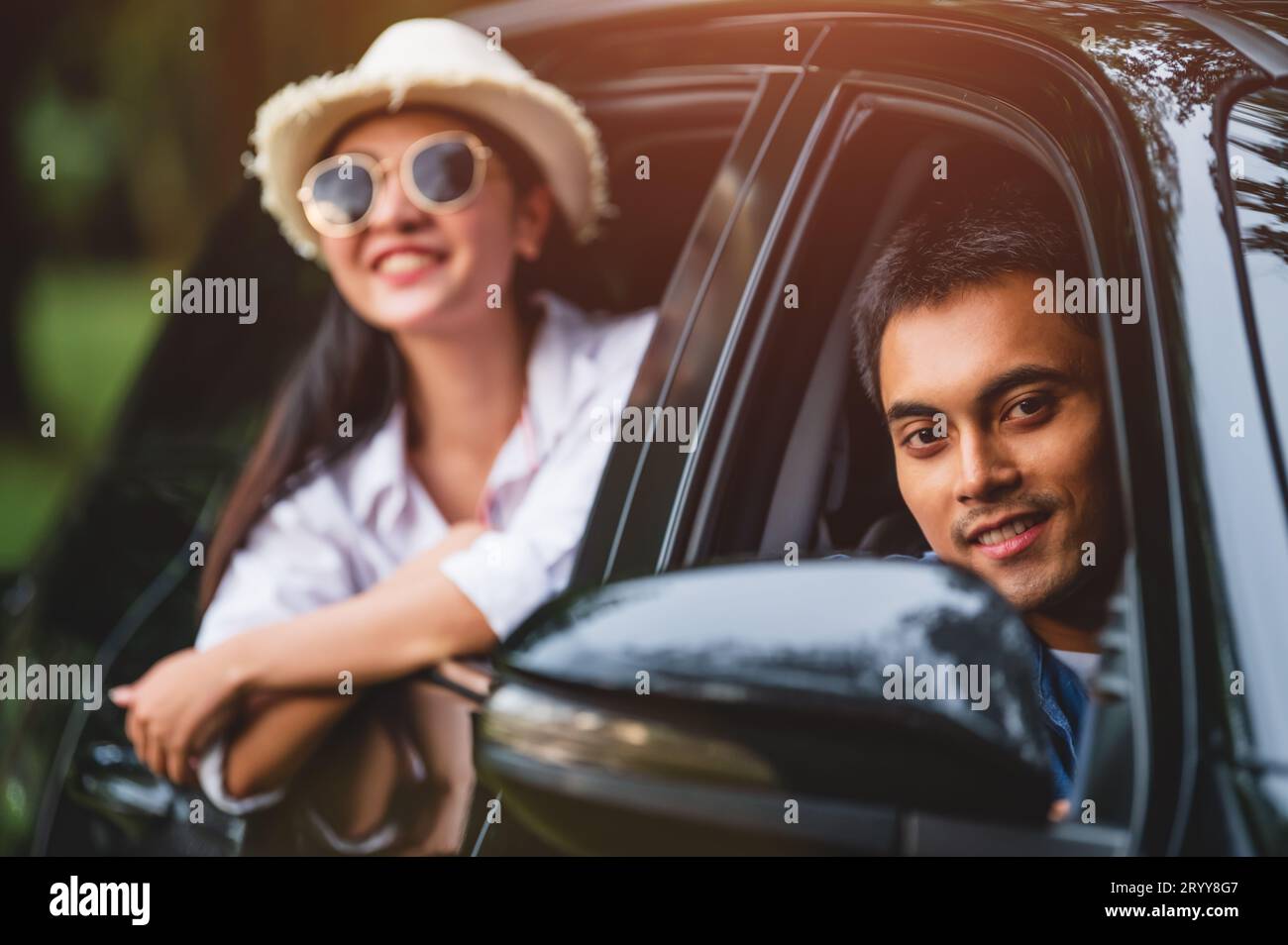 Homme asiatique heureux regardant à l'extérieur voiture à fenêtre ouverte avec sa petite amie sur fond de forêt. Le style de vie des gens se détendent en tant que voyageur Banque D'Images