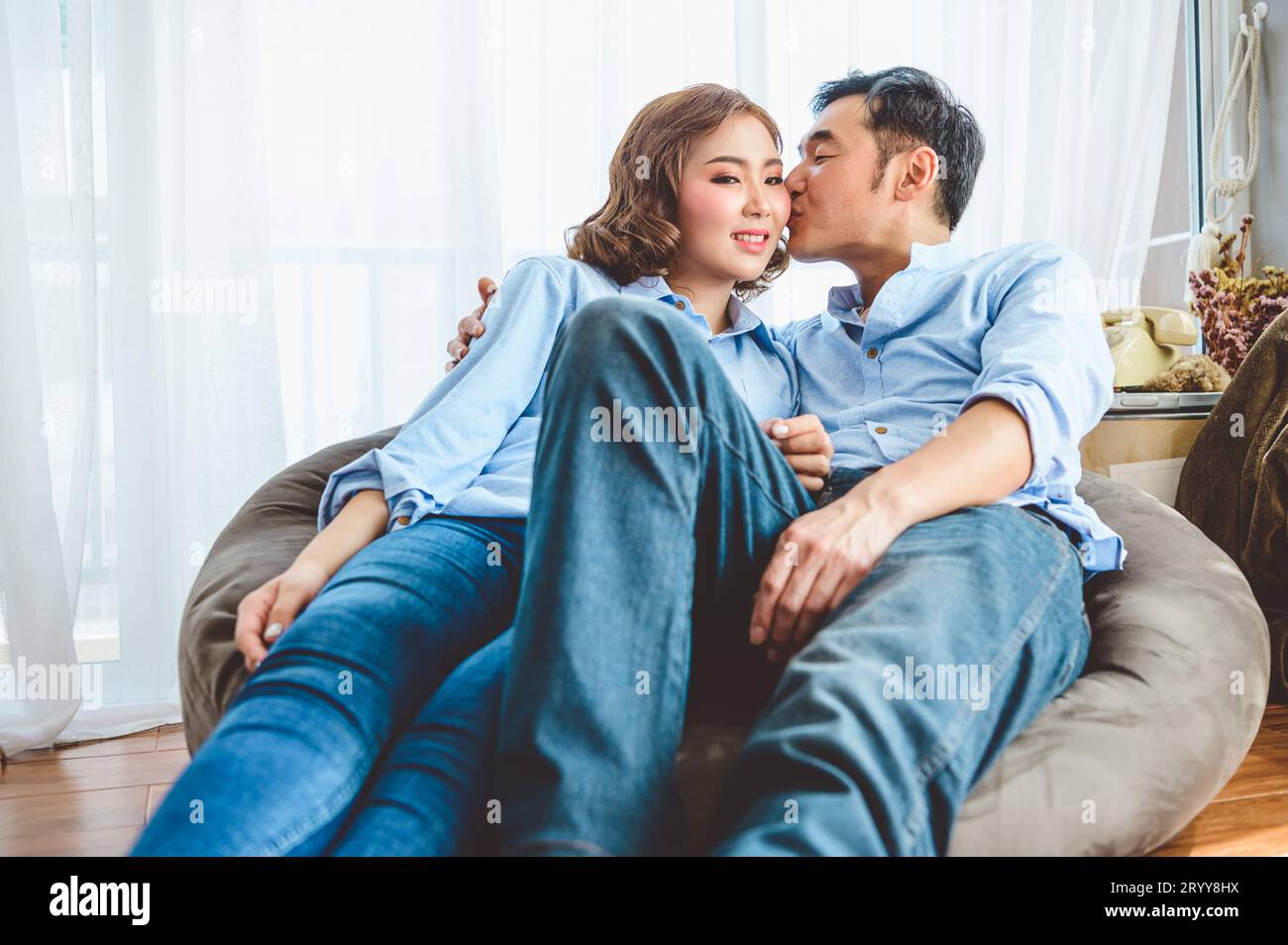 Couple asiatique ayant embrasser romance sur le canapé dans la maison domestique de salon dans la Saint Valentin. Style de vie et bonheur famille conc Banque D'Images