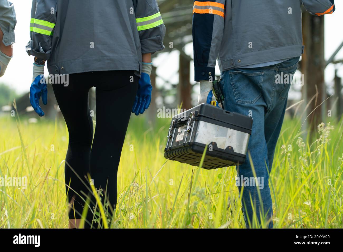 Ingénieurs et techniciens déchargeant des panneaux solaires réparés à installer sur les rangées de cellules solaires alignées sur des centaines de A. Banque D'Images