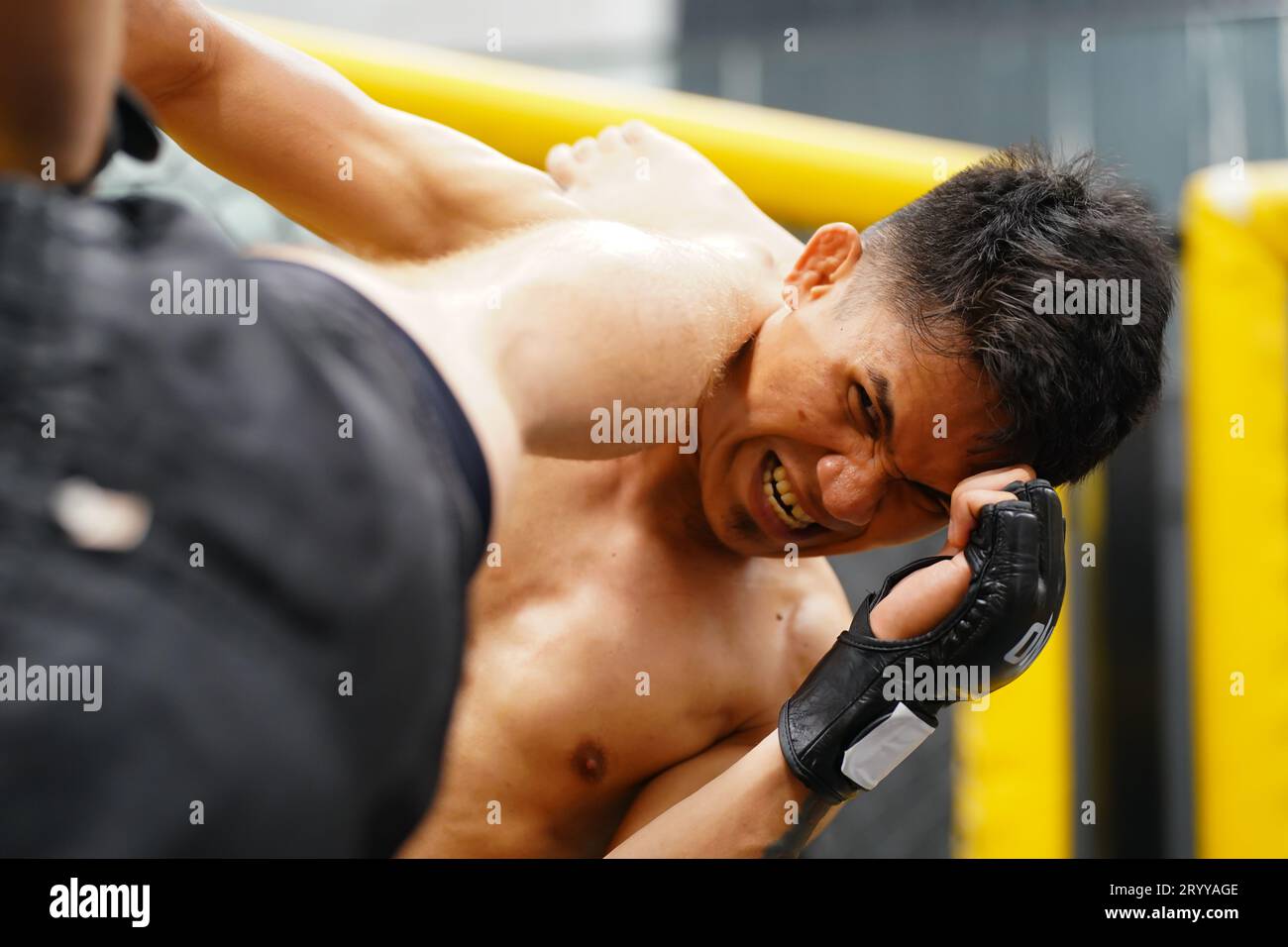 Art martial mixte, Un boxeur avec l'arme de coup de pied le cou la gorge de l'adversaire. Banque D'Images