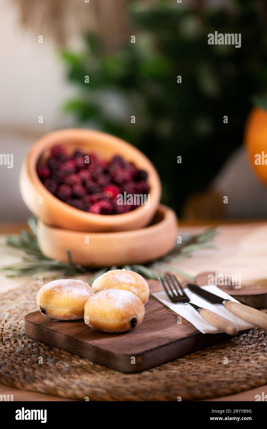 Biscuit fourré de chocolat avec couverts sur une planche à découper, servi avec du jus de pomme mousseux, des mûres rouges, des mandarines et un jack o'lanterne dans le bac Banque D'Images