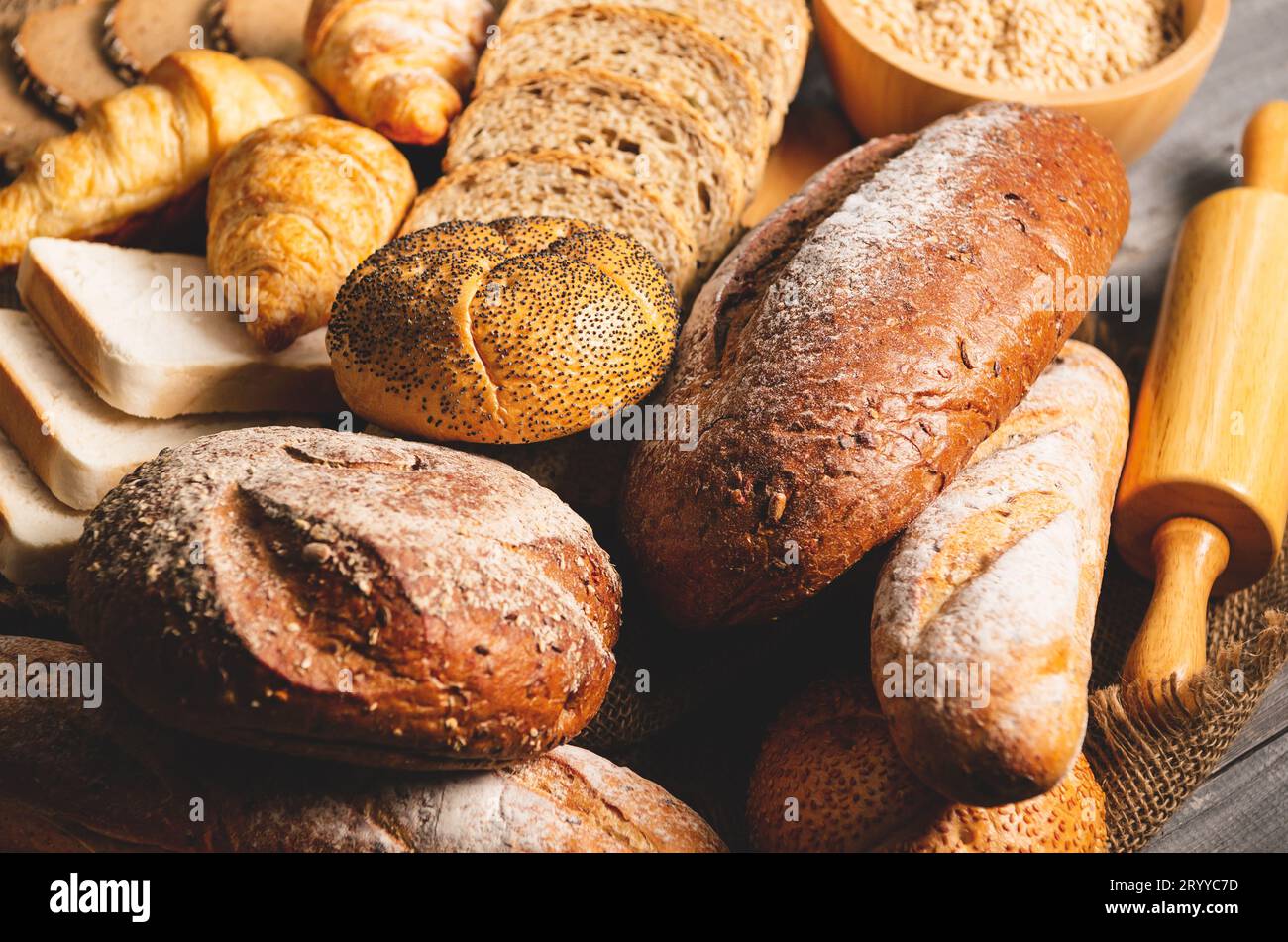 Différents types de pain avec nutrition grains entiers sur fond en bois. Nourriture et boulangerie dans le concept de cuisine. Délicieux petit déjeuner Banque D'Images