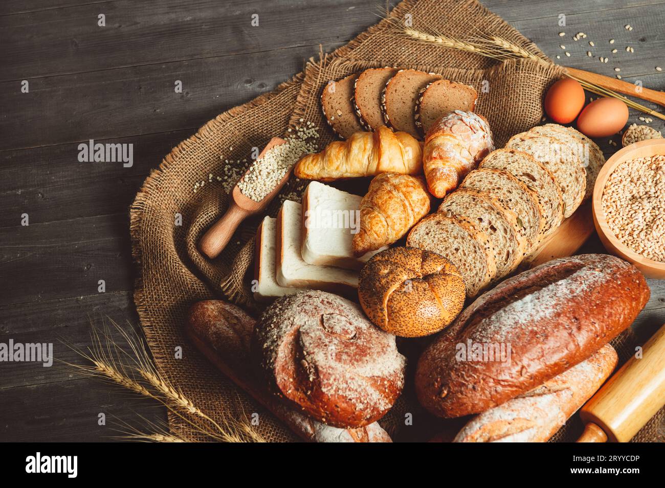 Différents types de pain avec nutrition grains entiers sur fond en bois. Nourriture et boulangerie dans le concept de cuisine. Délicieux petit déjeuner Banque D'Images