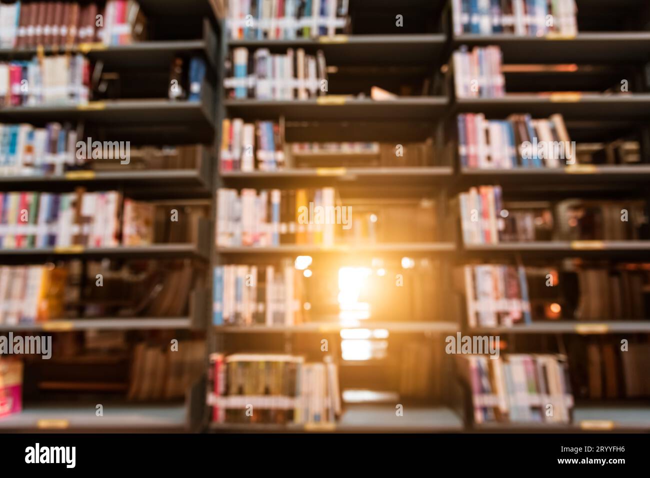 Arrière-plan flou dans la bibliothèque de l'université avec la lumière du soleil. Le résumé et l'auto apprentissage éducation concept. Banque D'Images