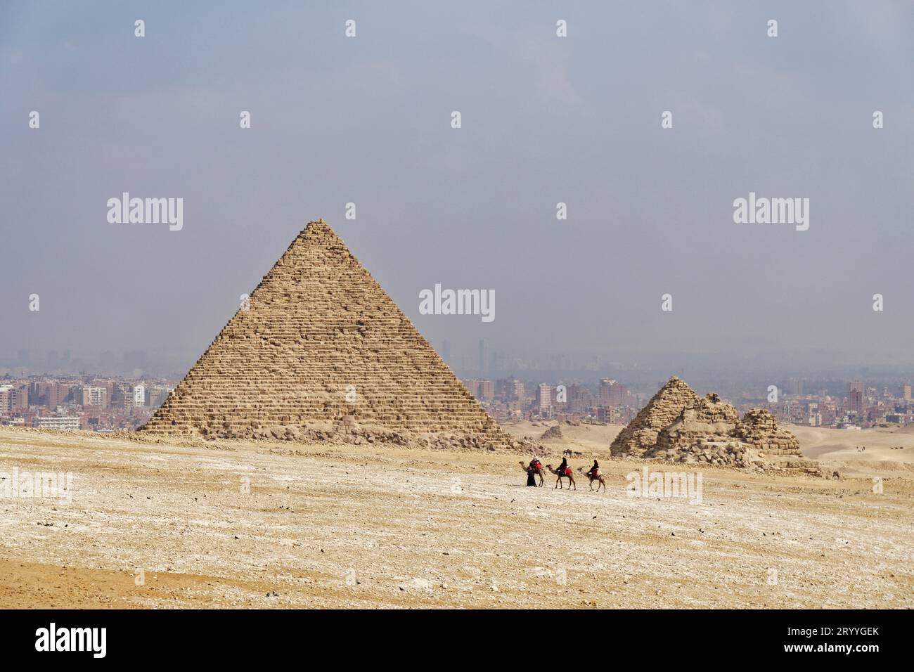 Guides de chameaux et chameaux devant la Pyramide de Mykerinos et les Pyramides de la Reine, désert, sable, chaleur, smog, Gizeh, Égypte Banque D'Images