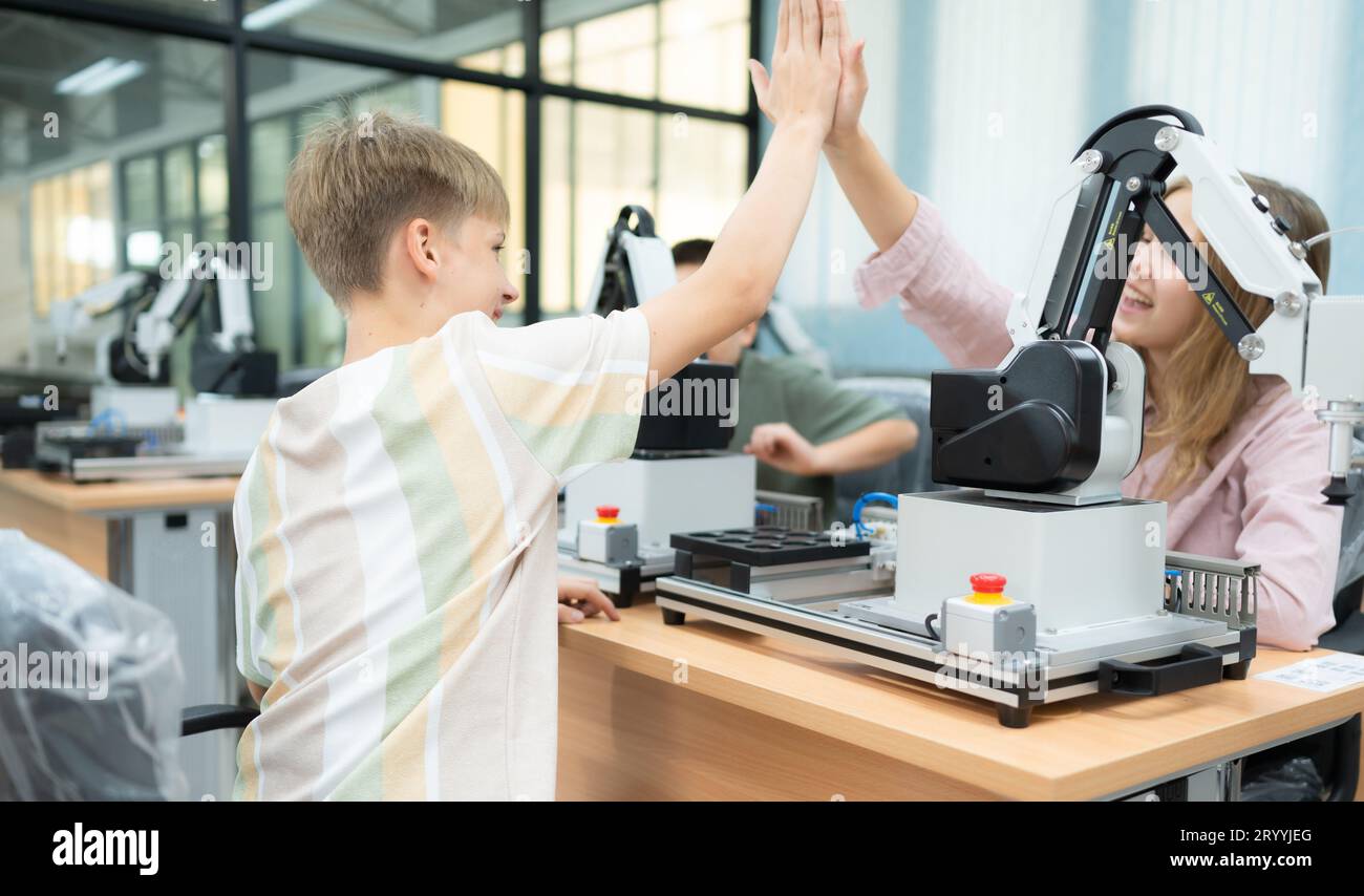 Enfants utilisant la technologie de robot de main et s'amusant apprendre, les étudiants étudient la technologie, qui est l'un des cou de TIGE Banque D'Images