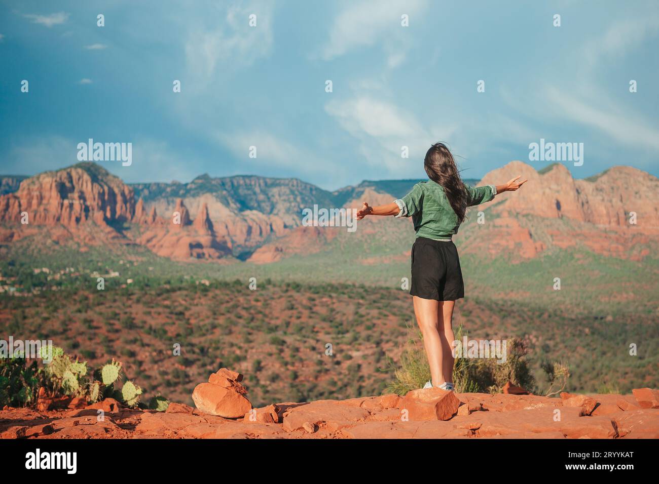 Jeune femme randonneuse au bord d'une falaise à Cathedral Rock à Sedona, Arizona. Vue depuis Scenic Cathedral Rock à Sedona avec bl Banque D'Images