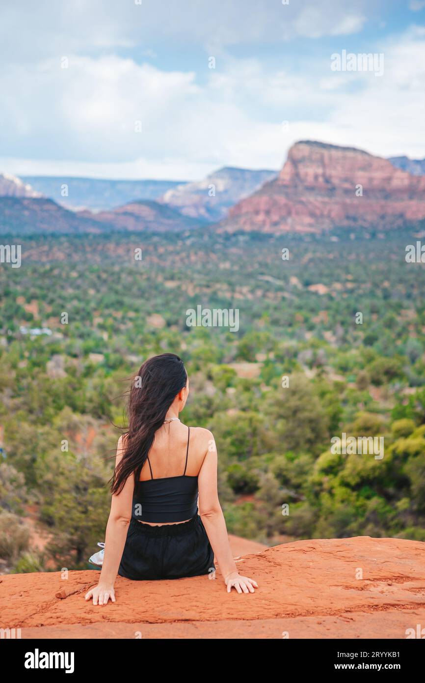 Jeune femme randonneuse au bord d'une falaise à Cathedral Rock à Sedona, Arizona. Vue depuis Scenic Cathedral Rock à Sedona avec bl Banque D'Images