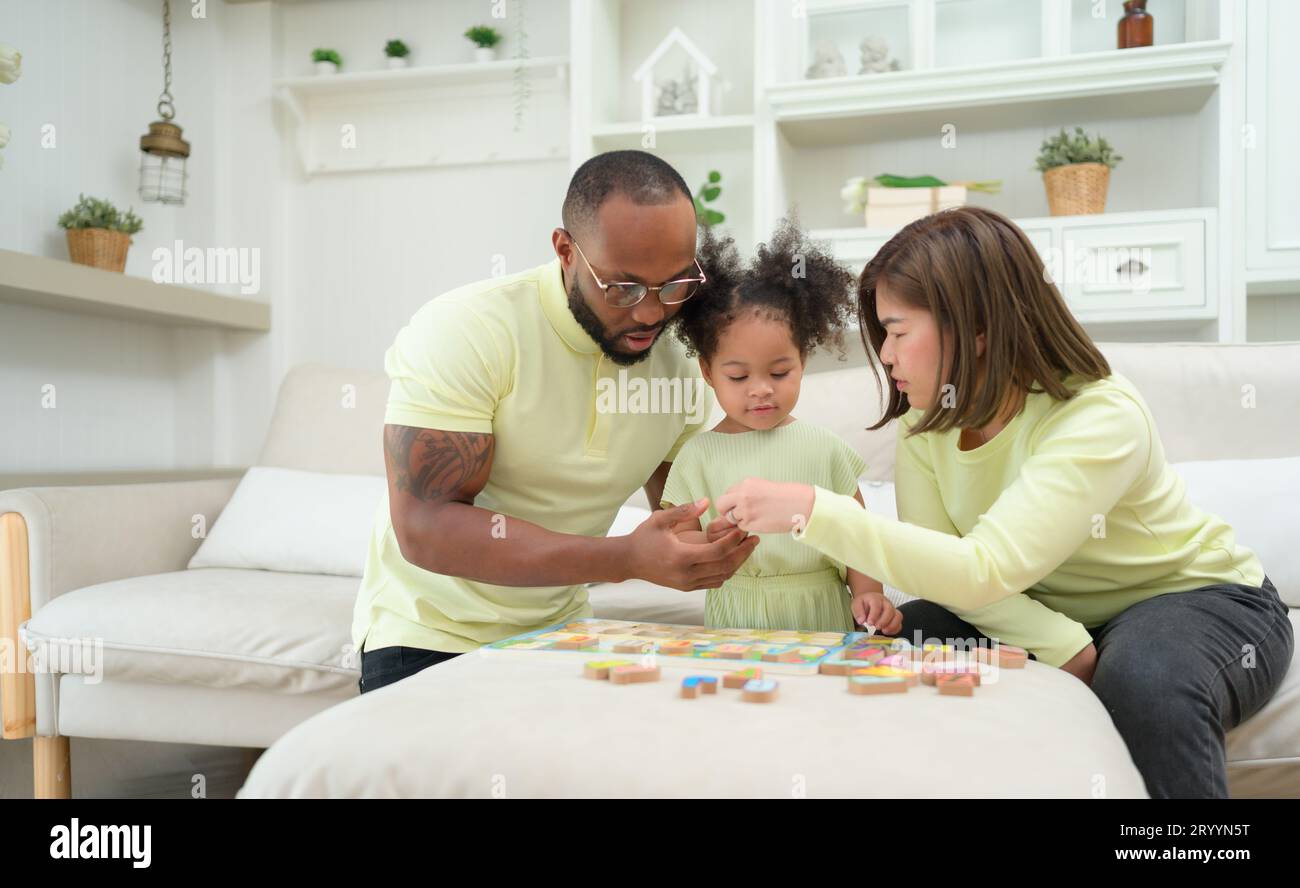 Père, mère et un enfant se reposant et s'amusant ensemble pendant leurs vacances à la maison. Banque D'Images