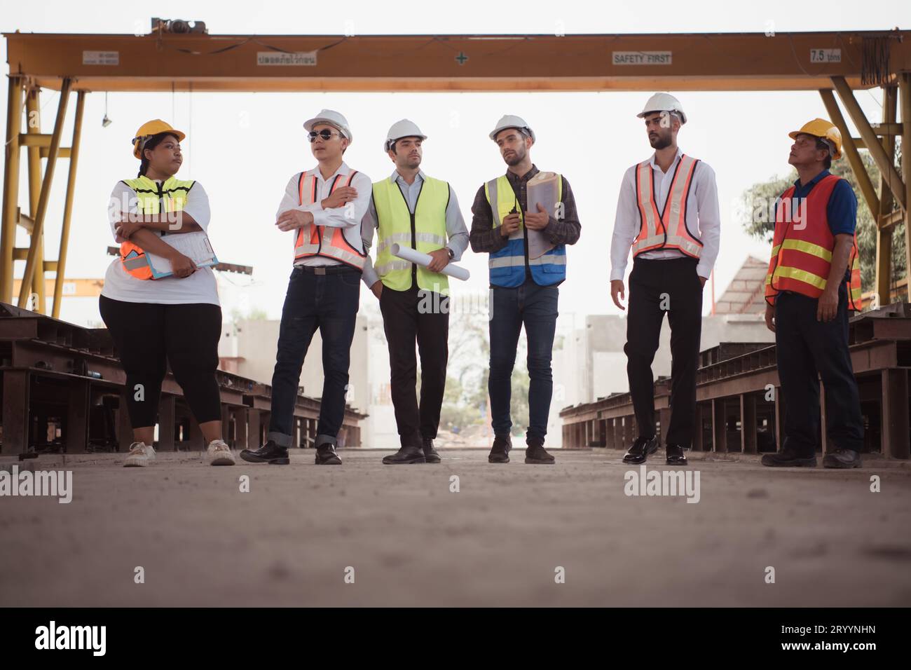 Groupe d'architectes, contremaîtres de construction, et les ingénieurs de construction examinent le travail et parlent de la façon dont le projet, dans le con Banque D'Images