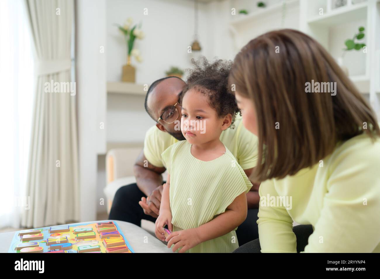 Père, mère et un enfant se reposant et s'amusant ensemble pendant leurs vacances à la maison. Banque D'Images