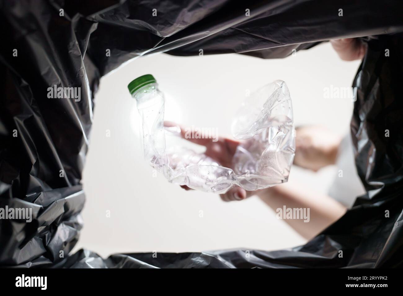 Image de l'intérieur du sac de recyclage jaune d'un homme jetant une bouteille en plastique vide dans un bac de recyclage Home recycle éco vert zéro concept Banque D'Images