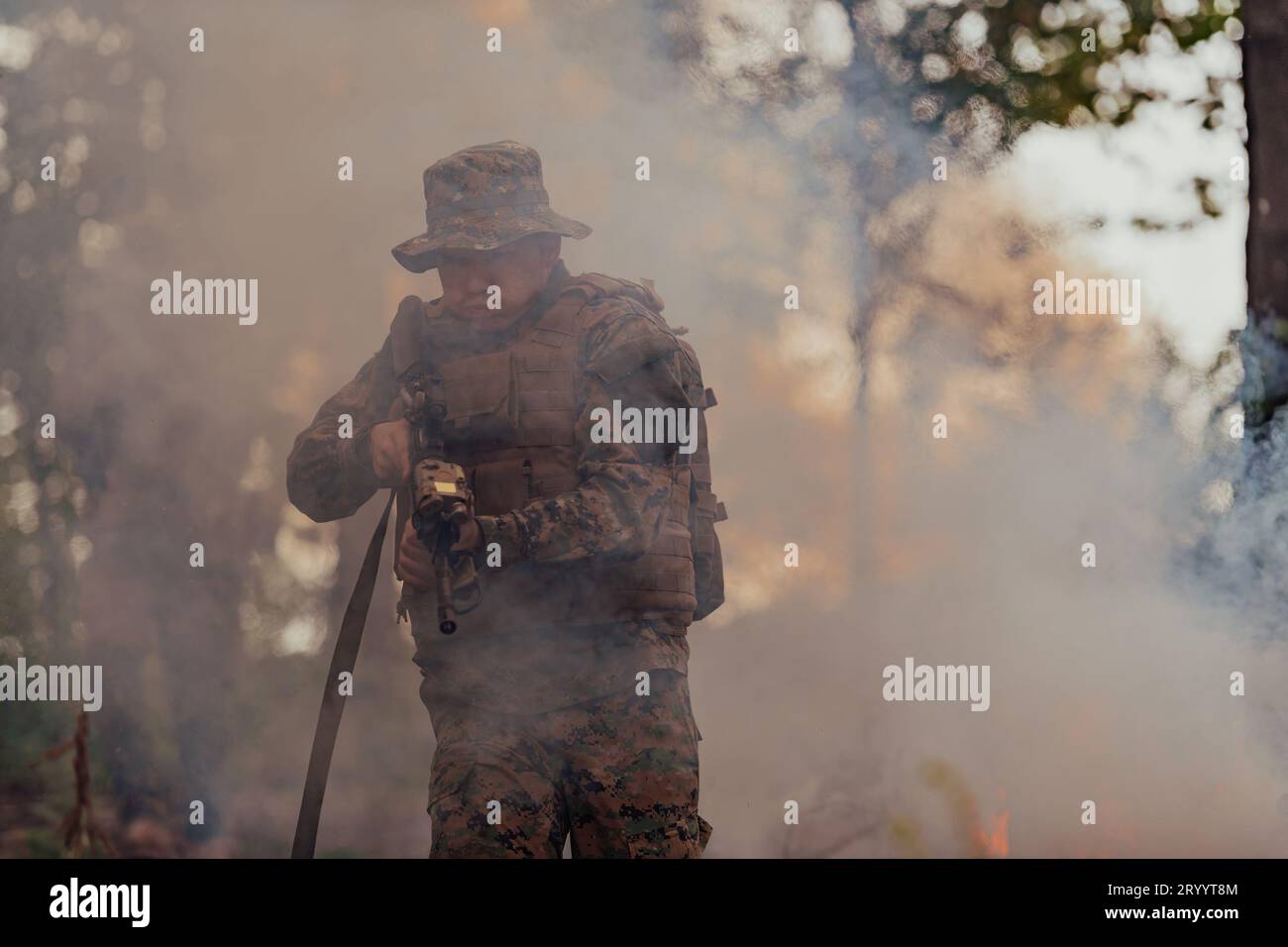 Un soldat combat dans une zone de forêt tropicale entourée de feu Banque D'Images