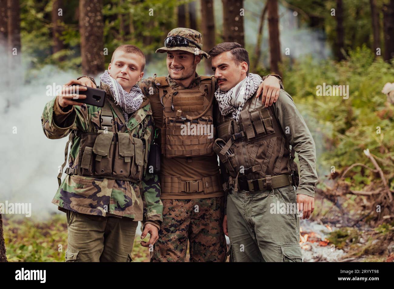 Équipe de soldats et terroristes prenant selfie avec smartphone dans la forêt Banque D'Images