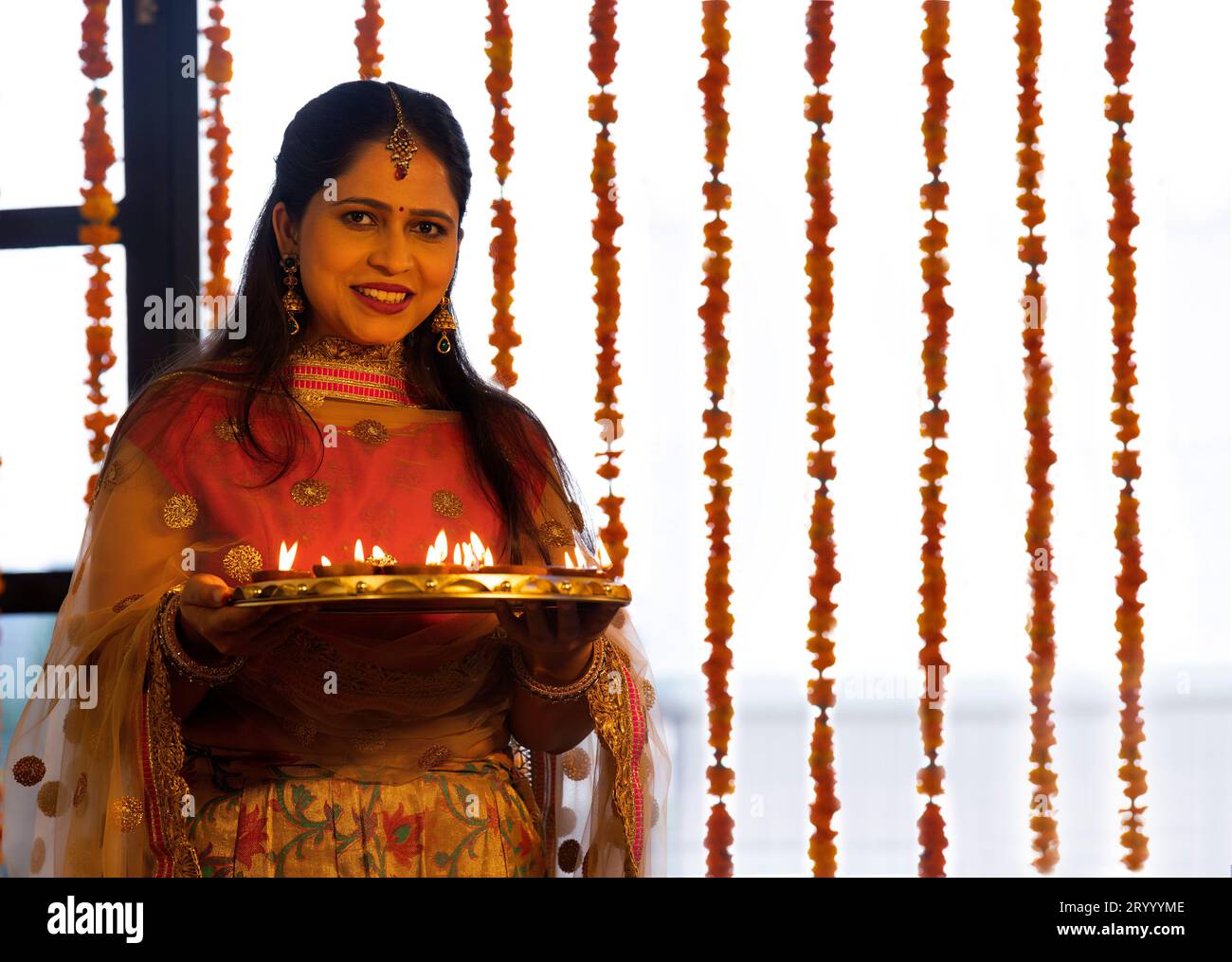 Portrait de femme joyeuse tenant un plateau de diyas à l'occasion de Diwali Banque D'Images