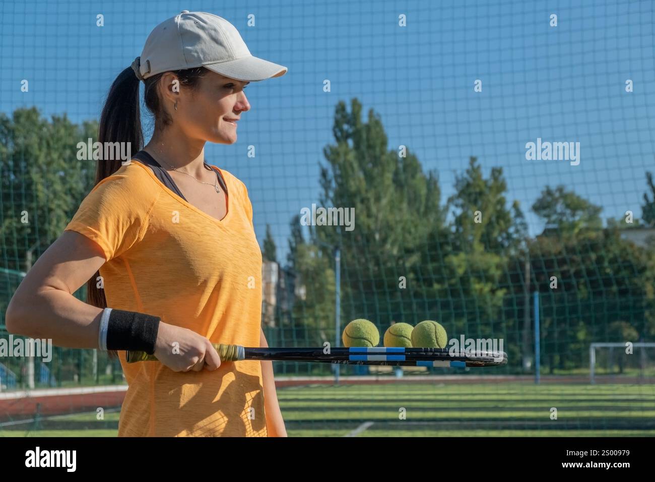 Jeune joueuse de tennis féminine tient des balles sur la raquette avant de servir Banque D'Images