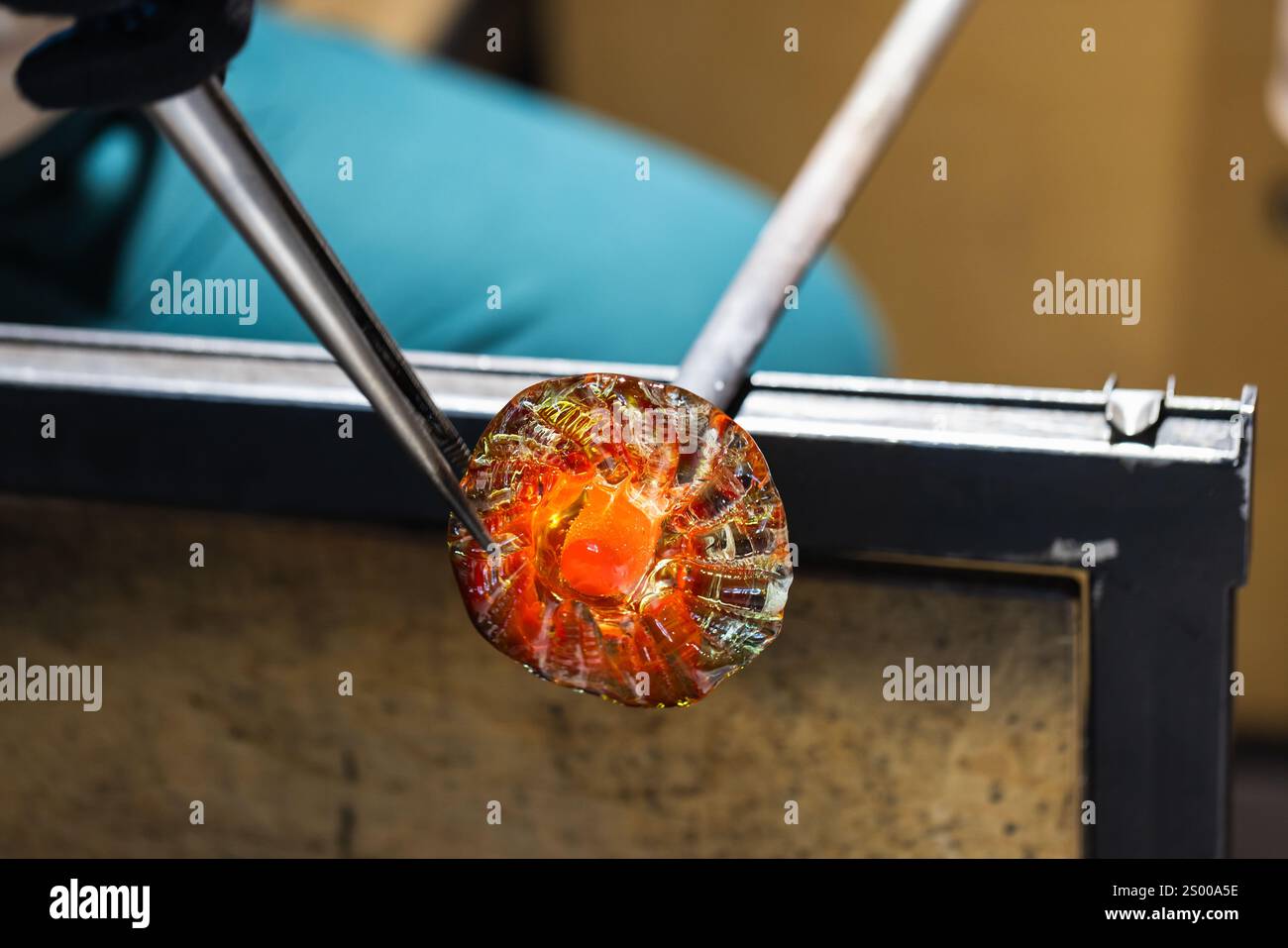 Travaux d'un atelier de soufflage de verre en cours. Verre fondu en forme de fleur Banque D'Images