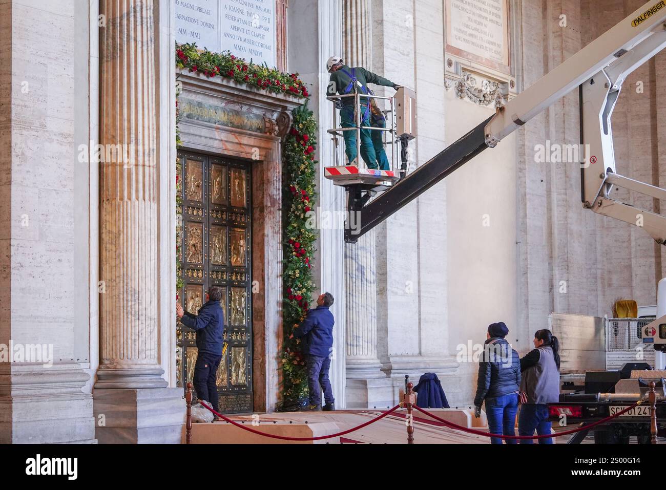 Rome, Italie. 23 décembre 2024 la porte Sainte (Porta Sancta) de la Basilique Saint-Pierre est en cours de décoration et sera officiellement ouverte à 19h le 24 décembre par le Pape François pour inaugurer le Jubilé de l'espérance 2025 et le début de l'année Sainte. .. La porte Sainte est ouverte tous les 25 ans et plus de 30 miilons sont attendus pour passer par la porte et chercher le pardon pour leurs péchés crédit. Amer Ghazzal/Alamy Live News Banque D'Images