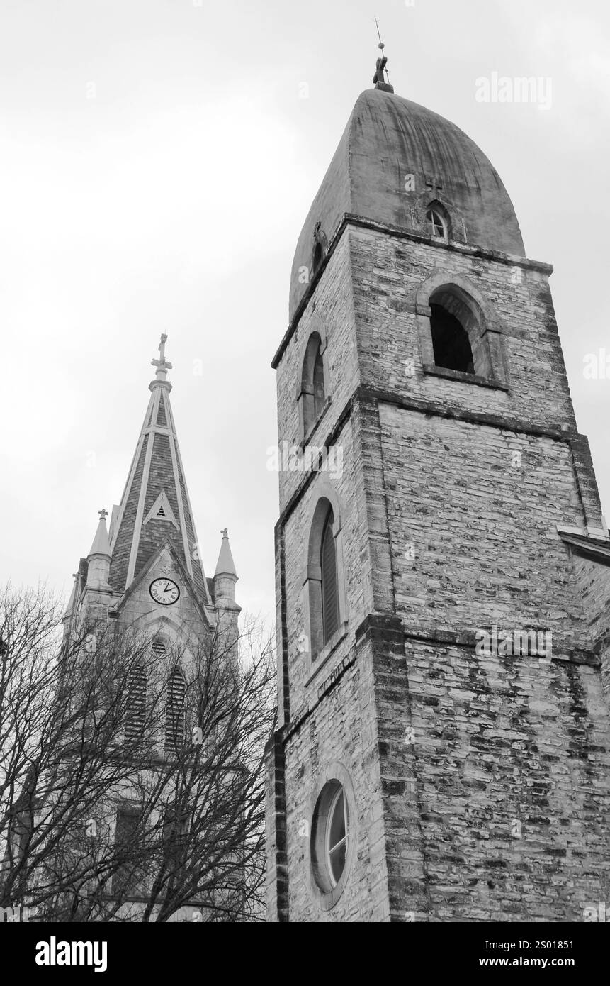 La tour et le clocher de Old Saint Mary's Parrish et son homologue plus récent dominent un pâté de maisons de Fredericksburg, Texas. La vieille église était comp Banque D'Images