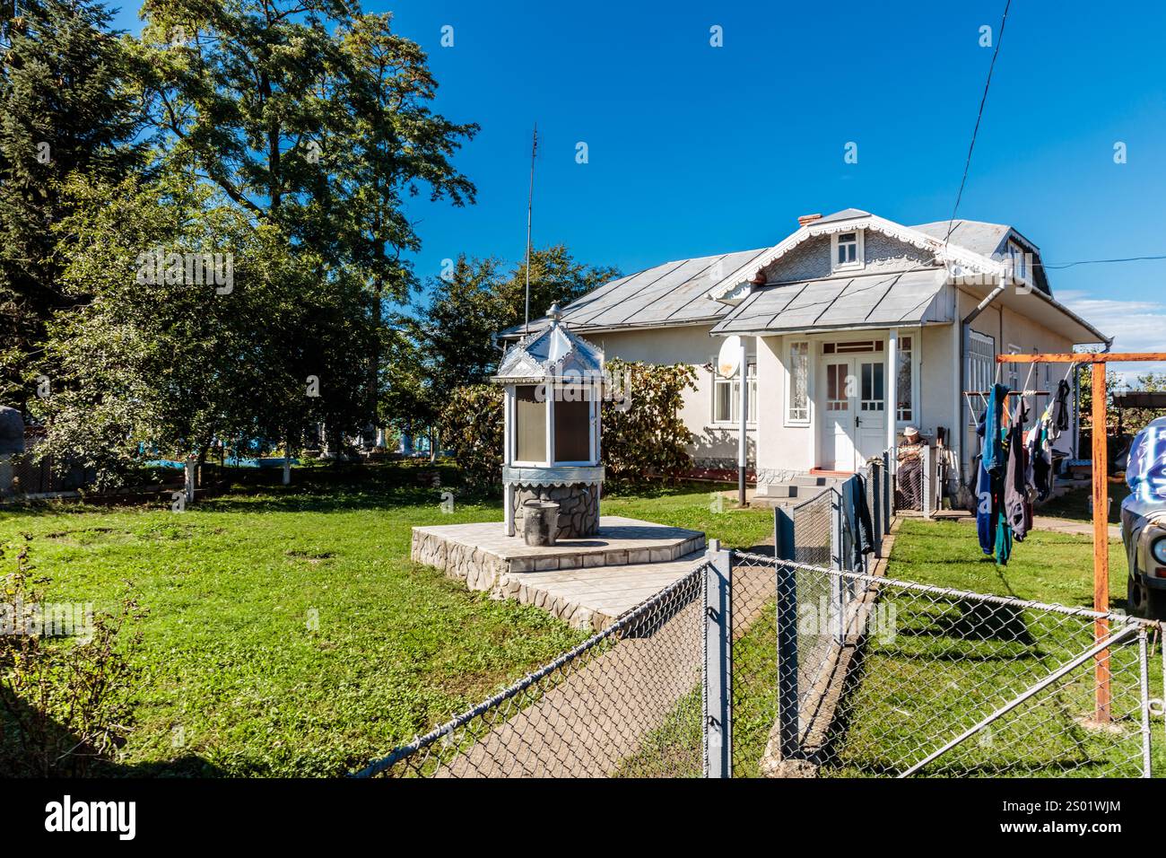 Une maison avec un toit blanc et une clôture blanche. La clôture est couverte de vêtements qui y sont accrochés Banque D'Images