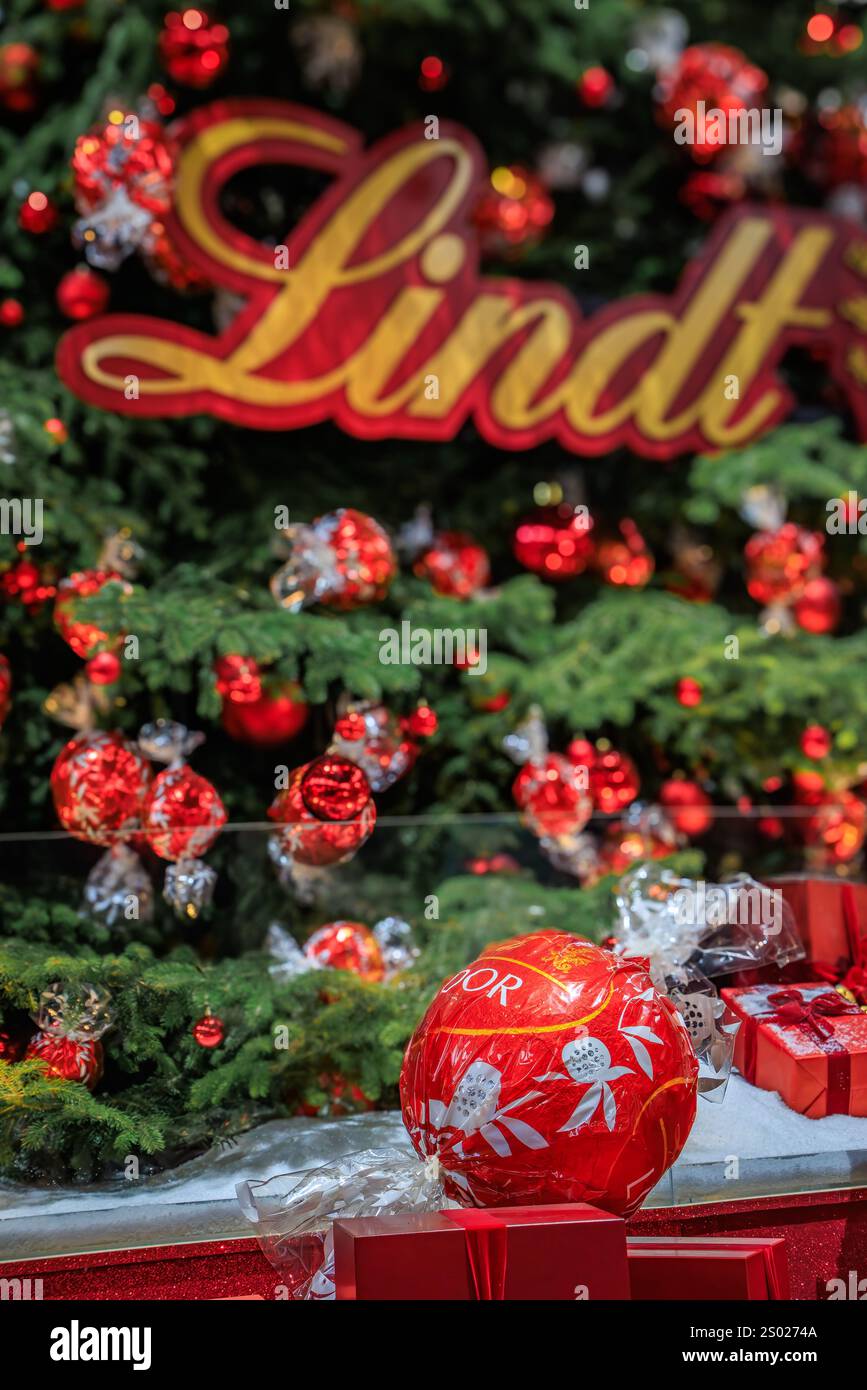 Zurich, Suisse - 24 novembre 2024 : arbre de Noël emblématique Lindt à Zurich SBB Hauptbahnhof orné d'ornements rouges et de décorations en chocolat Banque D'Images