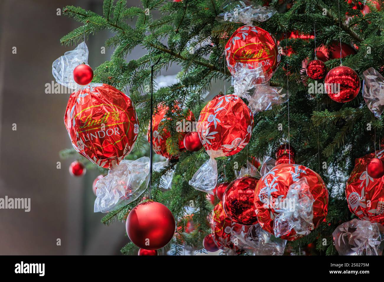 Zurich, Suisse - 24 novembre 2024 : arbre de Noël emblématique Lindt à Zurich SBB Hauptbahnhof orné d'ornements rouges et de décorations en chocolat Banque D'Images