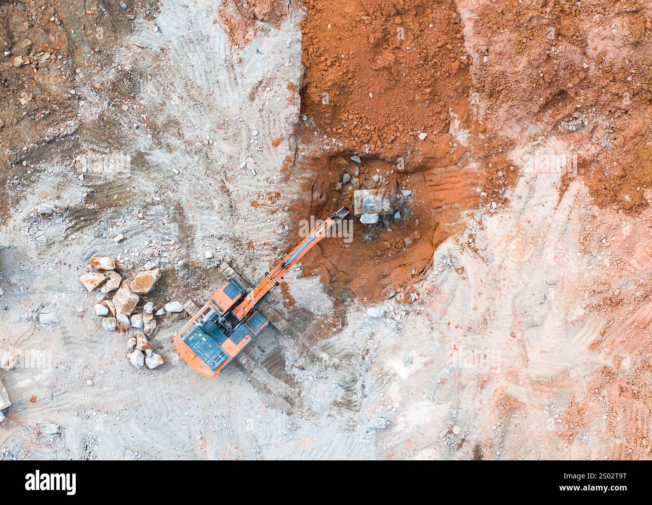 La grande pelle hydraulique à chenilles brise l'asphalte sur un chantier de construction Banque D'Images