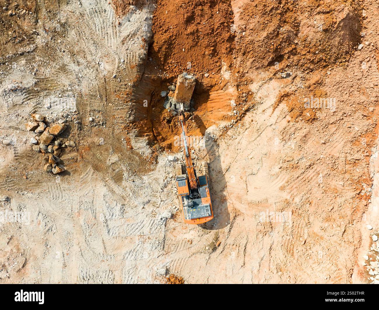La grande pelle hydraulique à chenilles brise l'asphalte sur un chantier de construction Banque D'Images