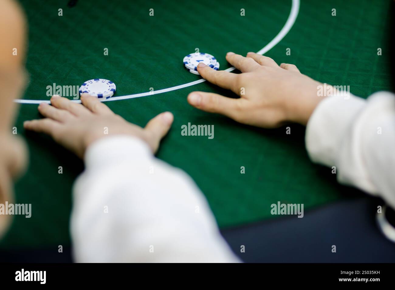 Plan détaillé des mains mélangeant des jetons de poker et tenant des cartes à jouer pendant une partie à enjeux élevés. Les couleurs vibrantes des puces et la texture nette Banque D'Images