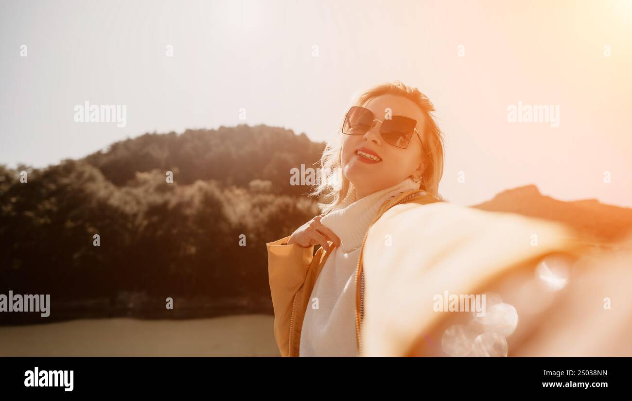 Femme lunettes de soleil Selfie montagnes paysage - femme heureuse prenant un selfie avec des lunettes de soleil et des montagnes en arrière-plan. Banque D'Images