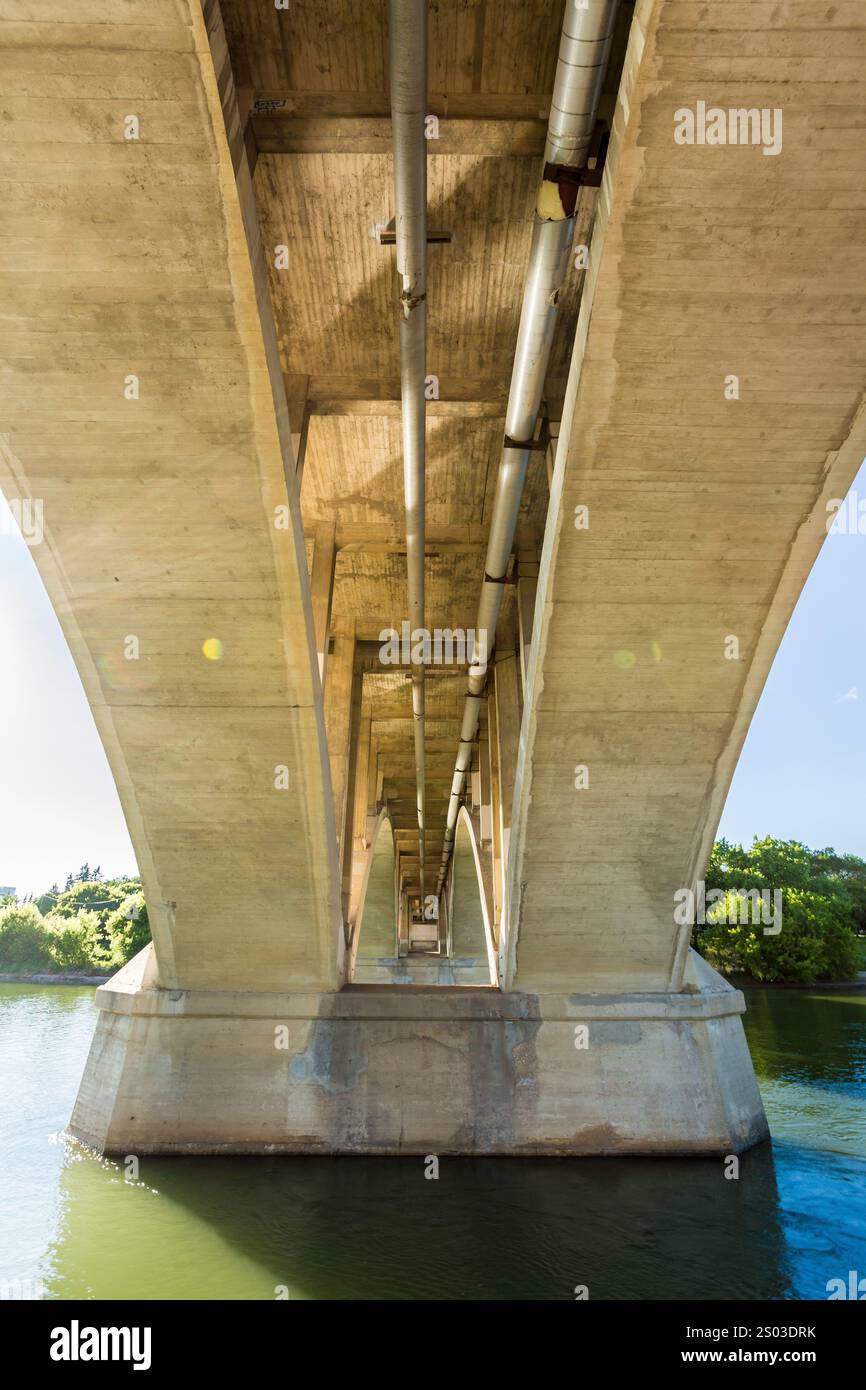 Le pont est long et étroit, avec beaucoup d'espace entre les deux côtés. L'eau ci-dessous est calme et claire, et le ciel est lumineux et ensoleillé. L'hybride Banque D'Images