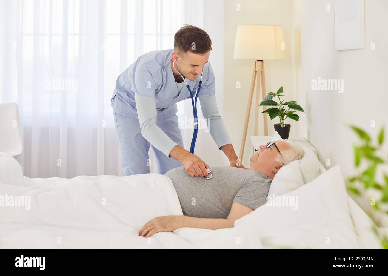 Vieil homme âgé couché dans son lit à domicile, jeune médecin, infirmier soignant le vieux patient Banque D'Images