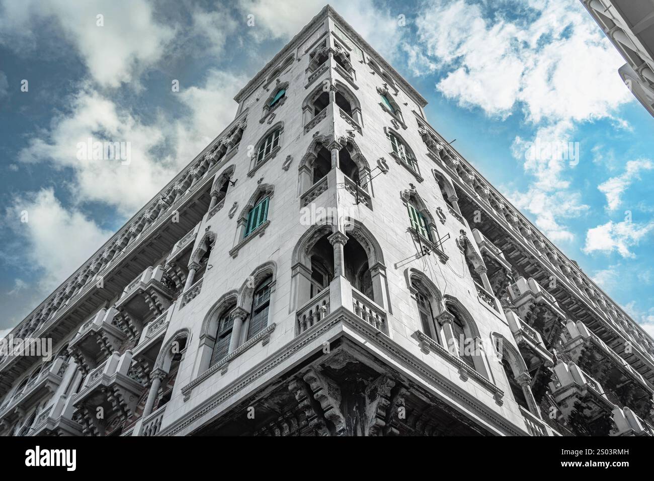 Un magnifique bâtiment historique à Alexandrie, en Égypte, avec des détails architecturaux complexes, des fenêtres cintrées et des volets turquoise vibrants. Banque D'Images