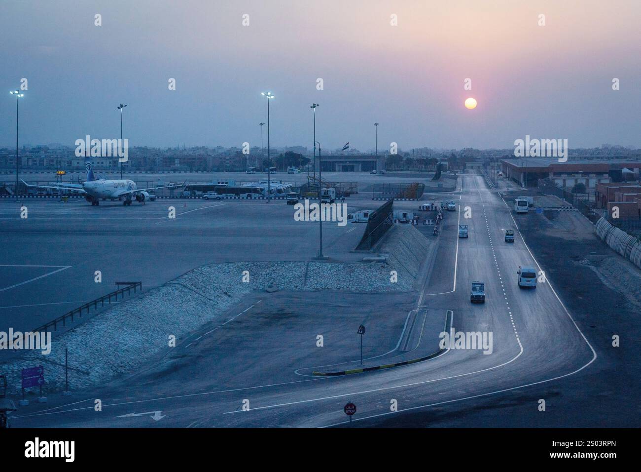 Vue panoramique de l'aéroport d'Alexandrie, Egypte, au crépuscule avec un avion sur la piste et le coucher de soleil en arrière-plan. Banque D'Images