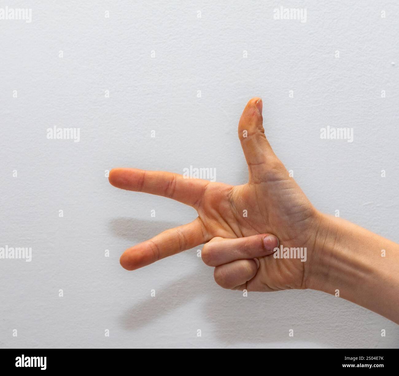 une seule main montrant trois doigts sur fond blanc, symbolisant le comptage, les options ou le nombre trois dans divers contextes Banque D'Images