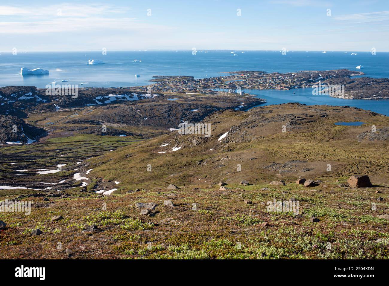 Cette image à couper le souffle capture la vue estivale de Qeqertarsuaq, située sur l'île de Disko, au Groenland, depuis une montagne voisine. Le village est vu nid Banque D'Images