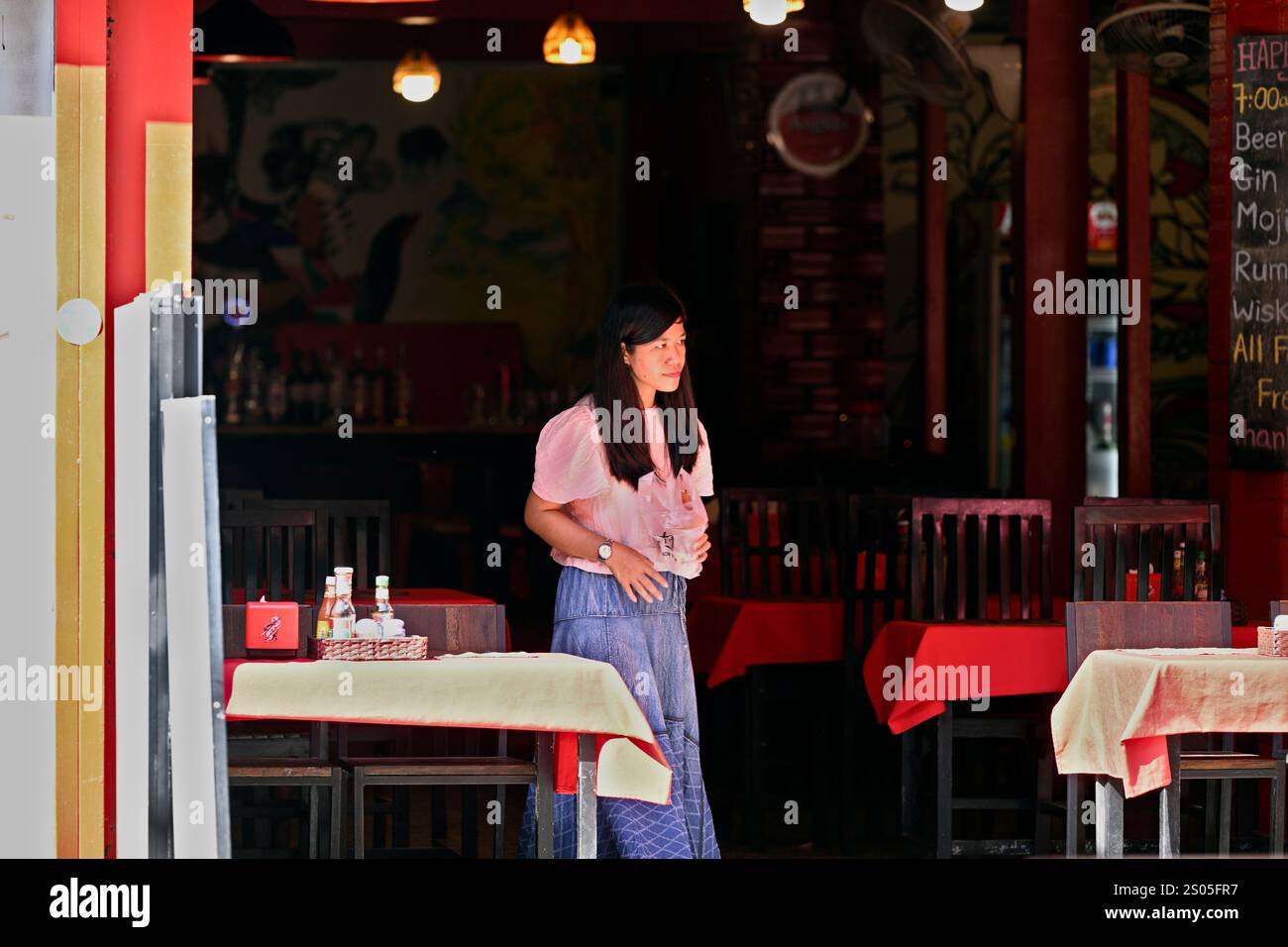 Une jeune serveuse cherche des clients dans un restaurant dans la dstination touristique de Siem Reap, au Cambodge. Banque D'Images