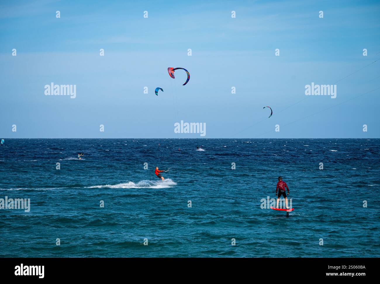 Un hydrofoiler s'approche d'un kitesurfer à Los Barriles, une petite ville du Cap oriental. La région est populaire auprès des amateurs de sports éoliens. Banque D'Images